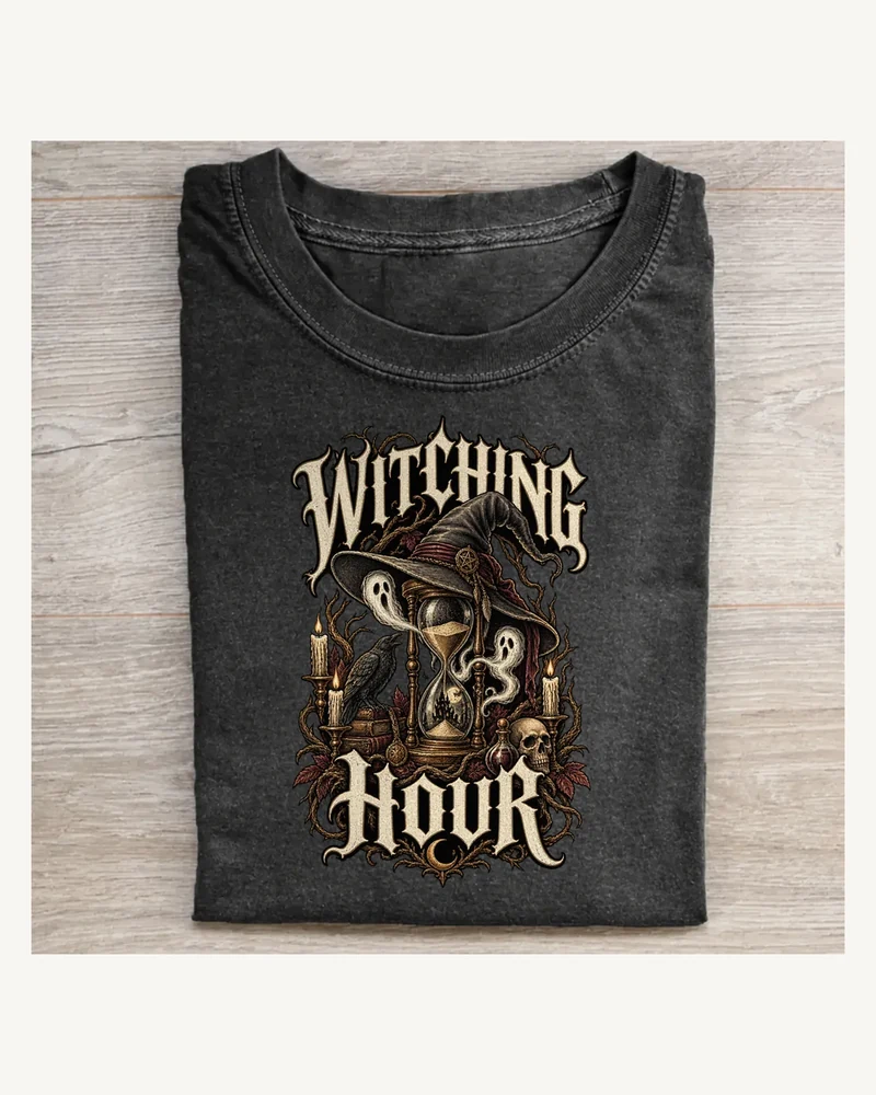 Folded washed black T-shirt featuring WITCHING HOUR gothic lettering and Halloween artwork