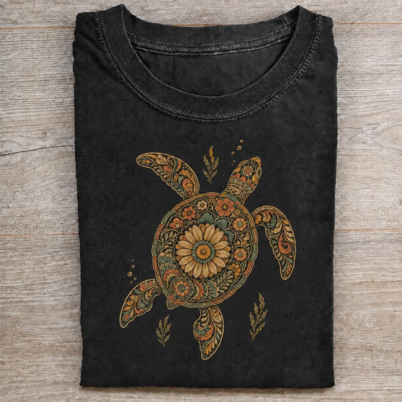 Folded washed black T-shirt with floral sea turtle artwork