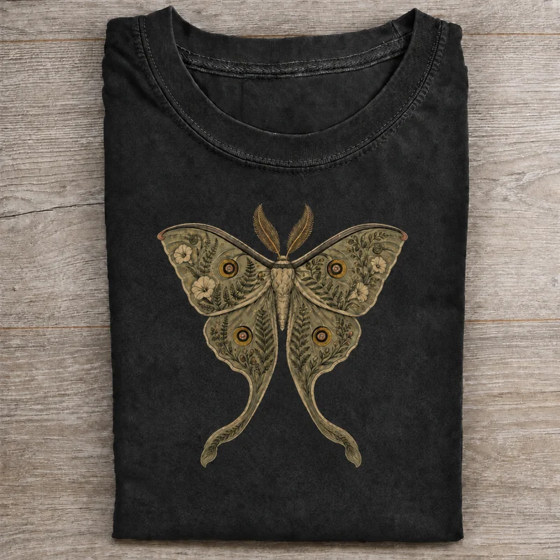Folded washed black T-shirt with botanical luna moth artwork