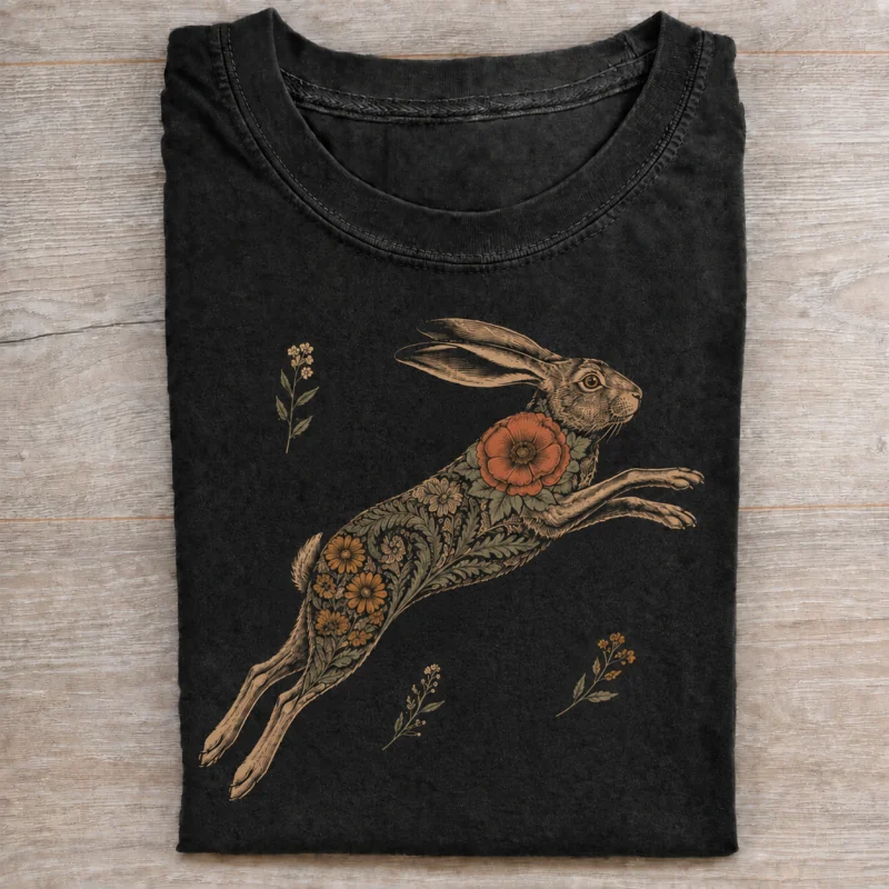 Folded washed black T-shirt with wildflower leaping hare artwork