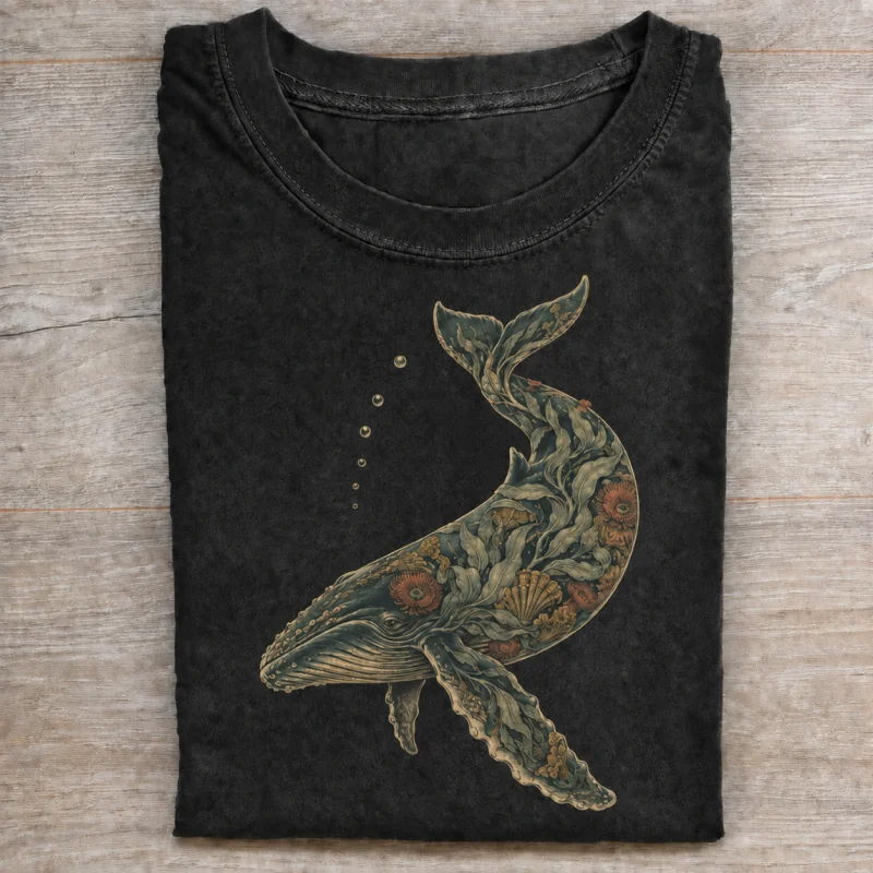 Folded washed black T-shirt with botanical tide whale artwork