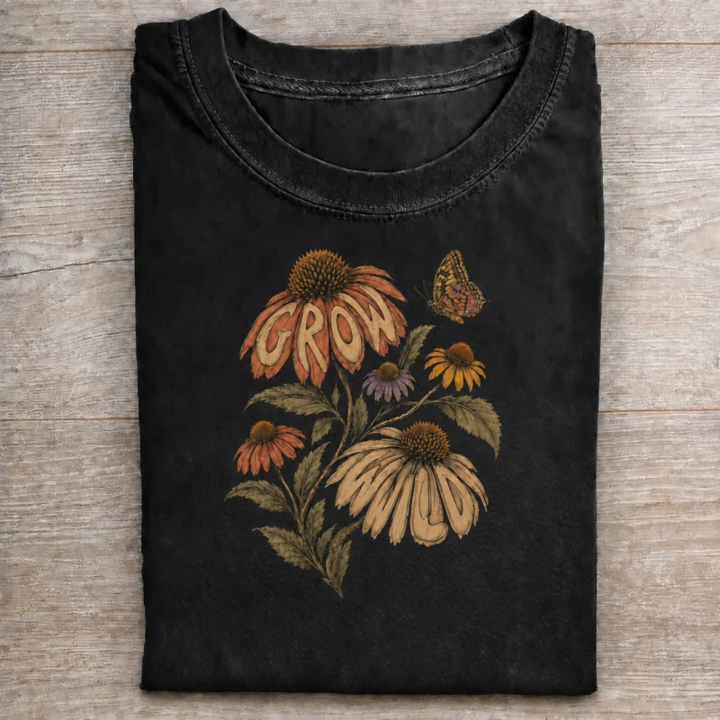 Folded washed black T-shirt with grow wild botanical artwork