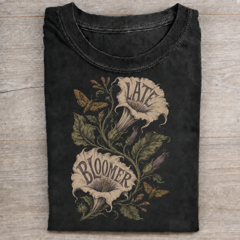Folded washed black T-shirt with late bloomer moonflower artwork